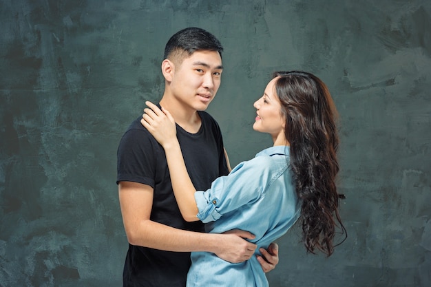 Free photo portrait of smiling korean couple on a gray