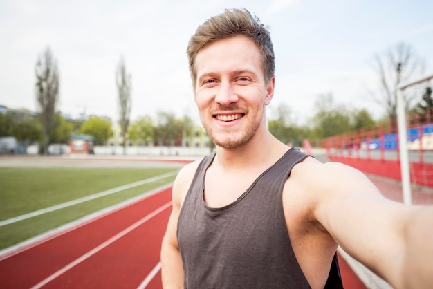 Портрет улыбающегося мужчины спортсмен говорит селфи на мобильном телефоне