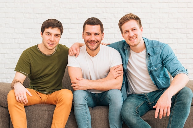 Портрет улыбающихся друзей мужского пола, сидели на диване