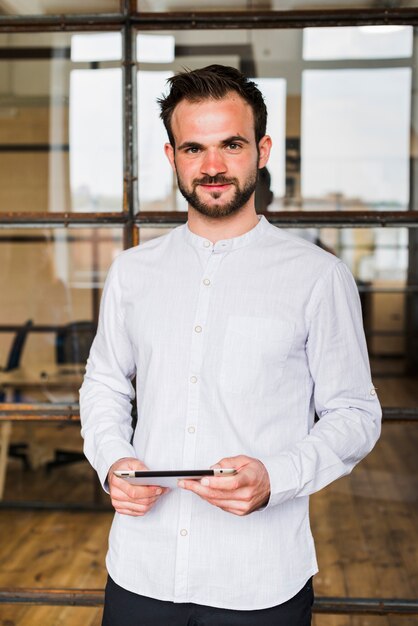 Portrait of smiling man holding digital tablet looking at camera