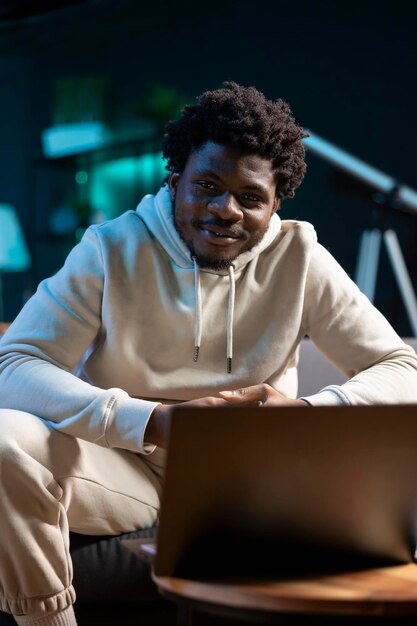 portrait of smiling man looking at laptop screen in stylish apartment
