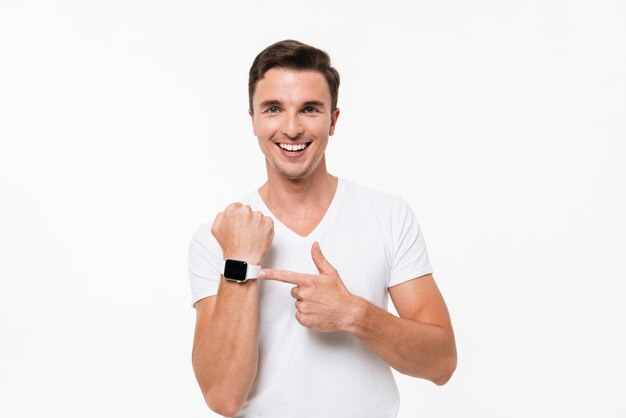 Portrait of a smiling man pointing finger at smart watch