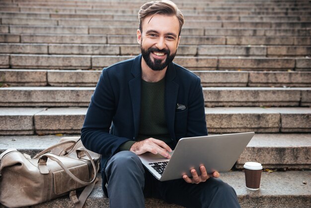 Portrait of a smiling man working on laptop