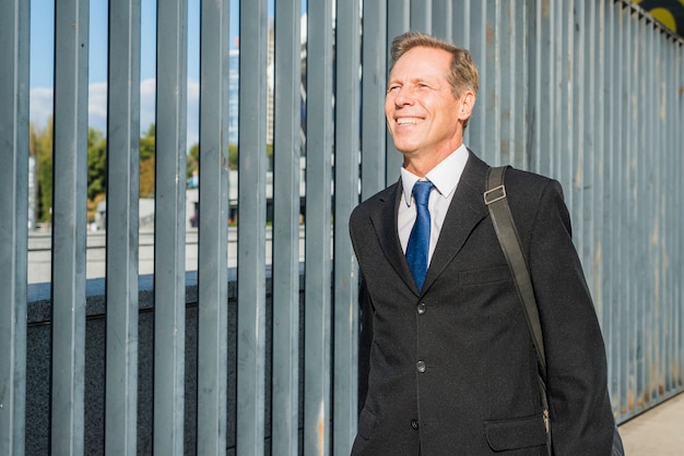 Free photo portrait of a smiling mature businessman at outdoors