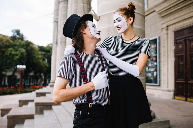 Portrait of a smiling mime couple looking at each other