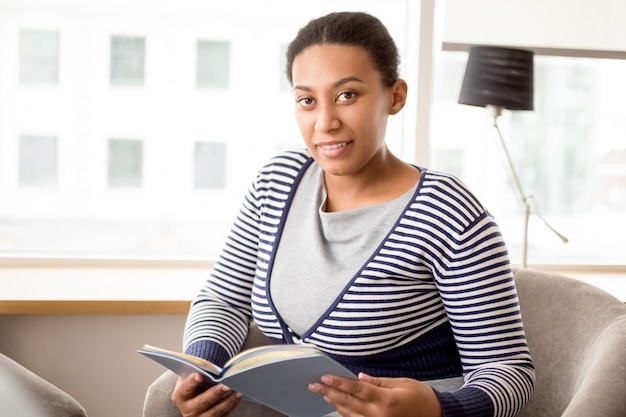 Portrait of smiling mixed race woman with book