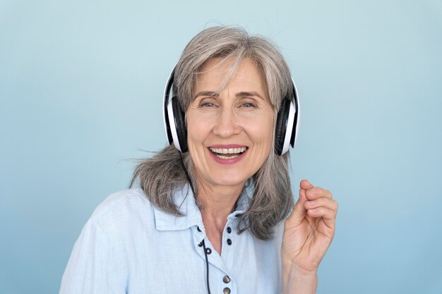 Portrait of smiling older woman using headphones