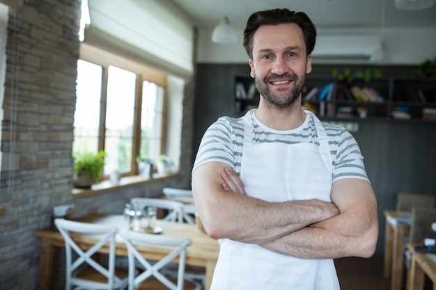 Foto gratuita ritratto di sorridere proprietario in piedi nel negozio di panetteria