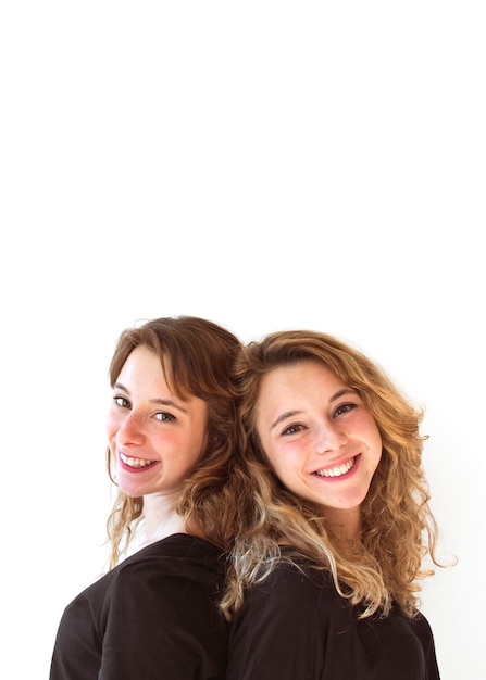 Portrait of smiling sister against white background