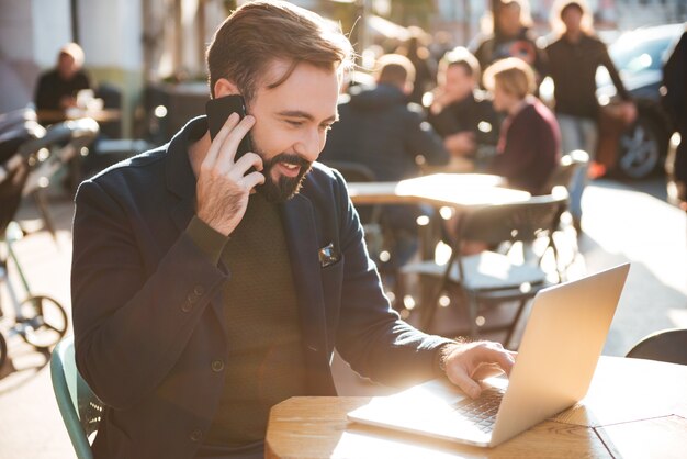 Portrait of a smiling stylish man working on laptop