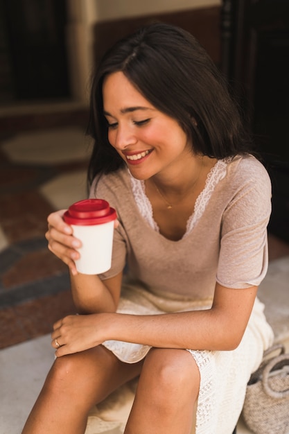 Portrait of a smiling teenage girl holding takeaway coffee cup