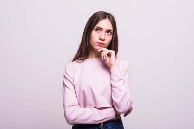 Portrait of a smiling thinking woman looking up isolated on white