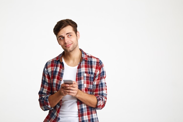 Portrait of a smiling thoughtful man holding mobile phone