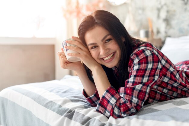 Portrait of smiling woman enjoying morning in bed