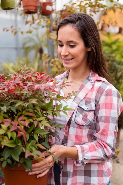 Free photo portrait of smiling woman holding big flower pot