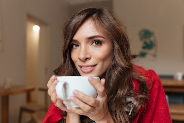 Free photo portrait of a smiling woman holding cup