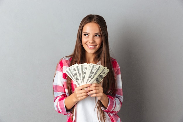Портрет улыбающейся женщины, держащей доллары