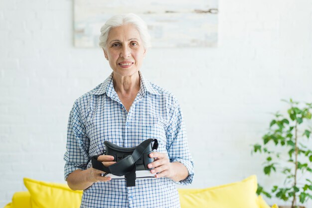 Portrait of smiling woman holding virtual reality glasses