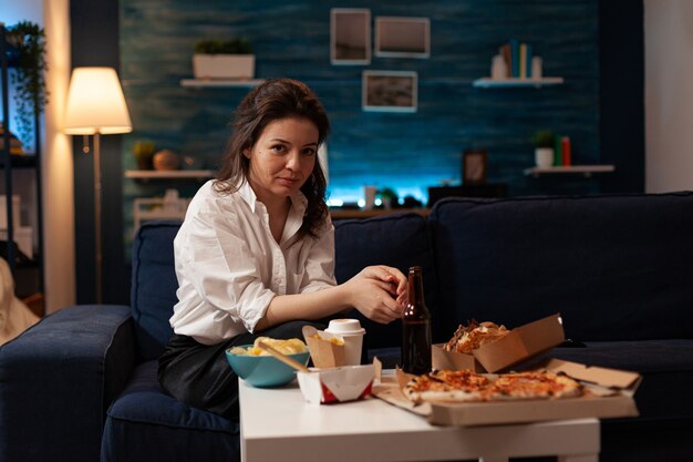 Portrait of smiling woman looking into camera sitting on couch enjoying free time