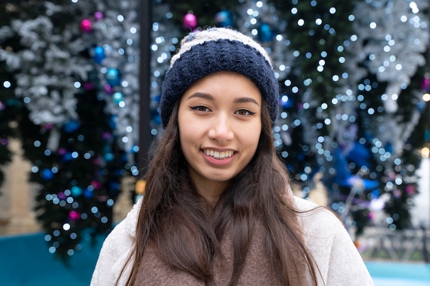 Free photo portrait of smiling woman outdoors with beanie