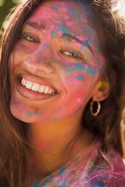 웃는 여자의 얼굴의 초상화는 holi 색상으로 덮여