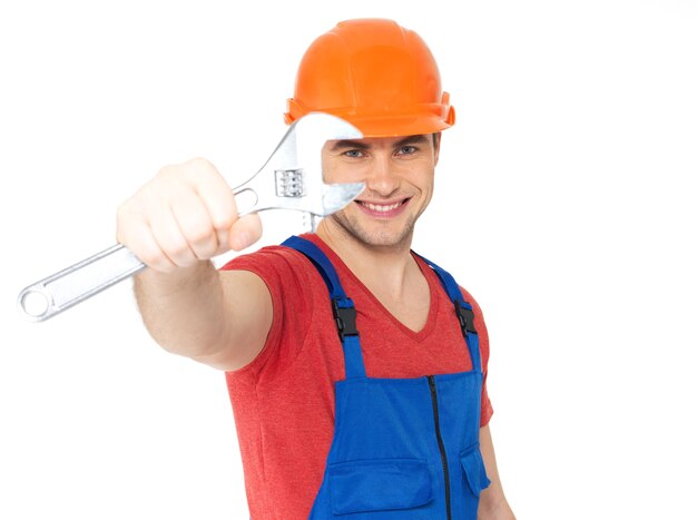 Portrait of smiling worker with big spanner isolated on white