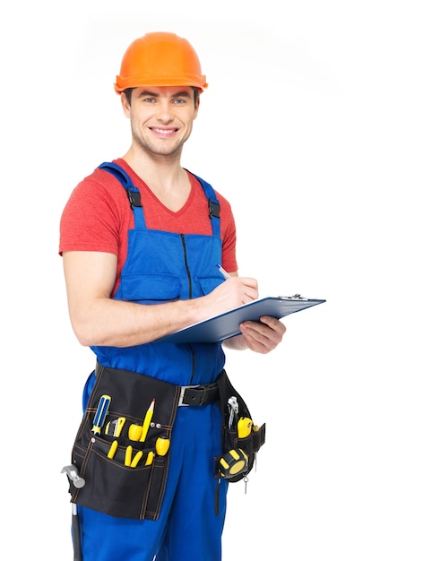 Free photo portrait of smiling worker with tools, planning and writing the note isolated on white