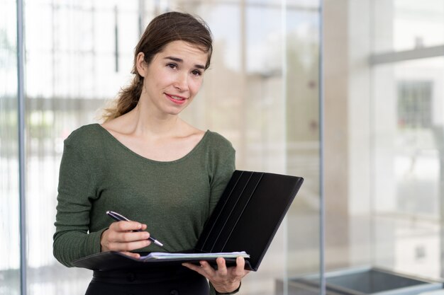 Portrait of smiling young businesswoman checking documents