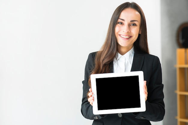 Portrait of a smiling young businesswoman showing touch screen digital tablet