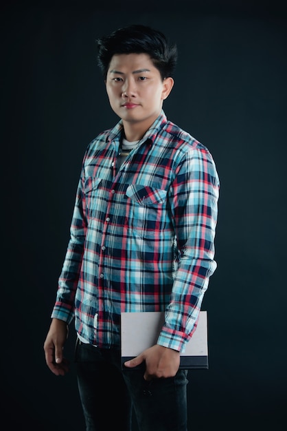 Portrait of smiling young college student with books