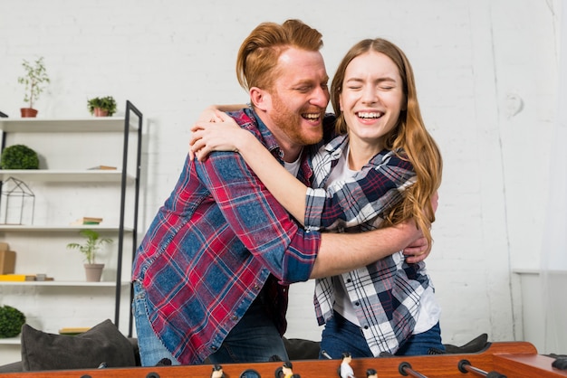 Portrait of smiling young couple embracing each other after playing the soccer game