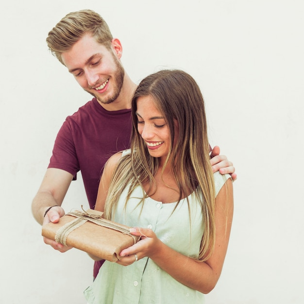 免费的照片微笑的年轻夫妇的画像拿着礼物