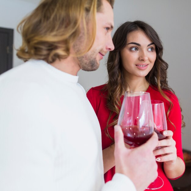 Free photo portrait of a smiling young couple holding wineglasses in hand