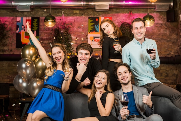 Portrait of a smiling young couples holding wine glasses enjoying party