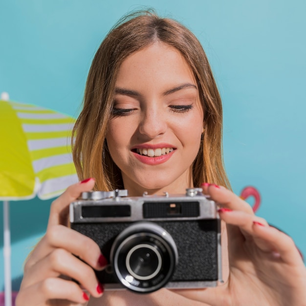 Portrait of smiling young female taking pictures on camera