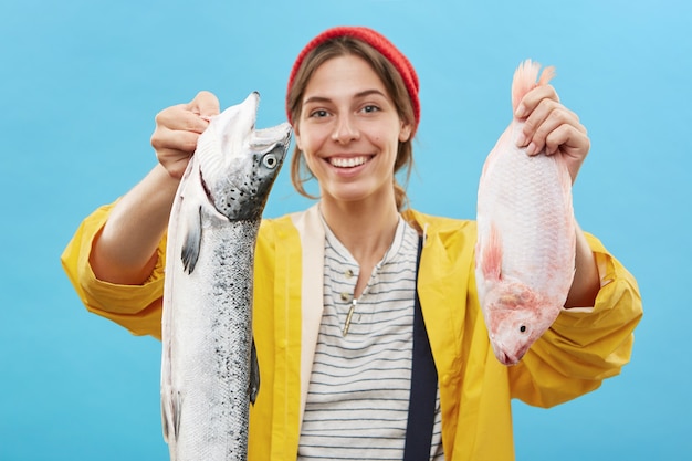 낚시 여행에서 오는 웃는 젊은 fisherwoman의 초상화