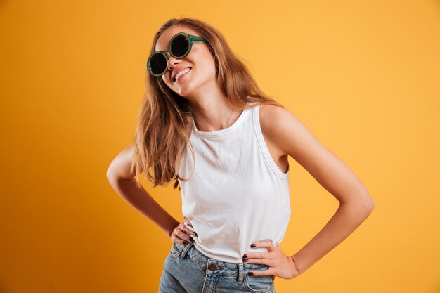 Портрет улыбающейся молодой девушки в солнцезащитных очках