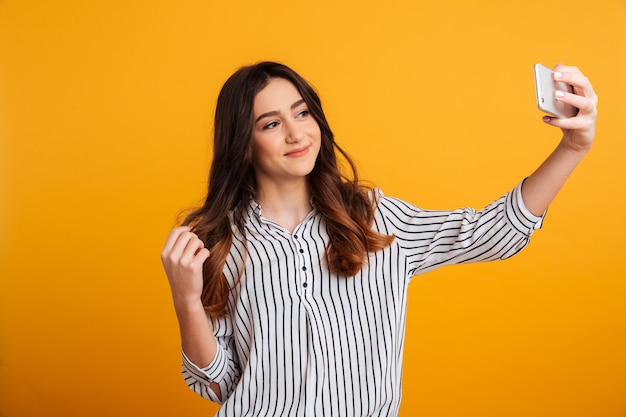 Portrait of a smiling young girl taking a selfie