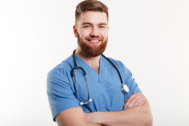 Portrait of a smiling young man doctor with stethoscope standing with arms folded