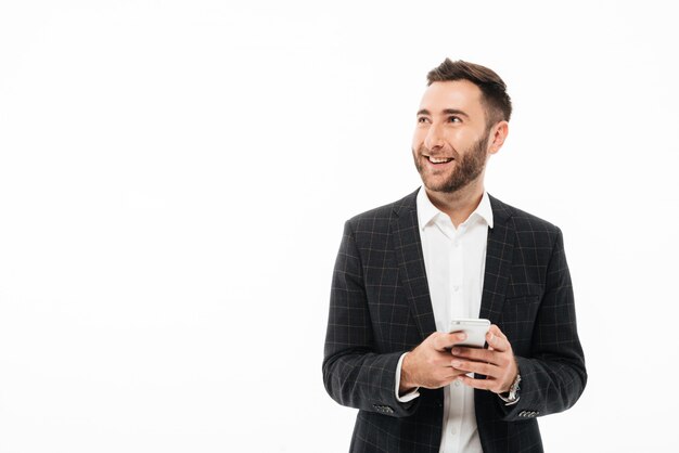 Портрет улыбающегося молодого человека, держащего мобильный телефон