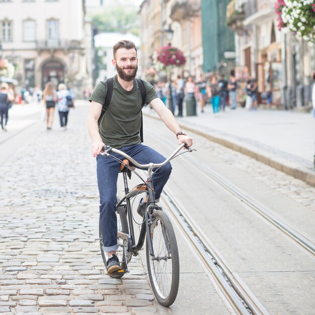 야외에서 자전거를 타고 웃는 젊은 남자의 초상
