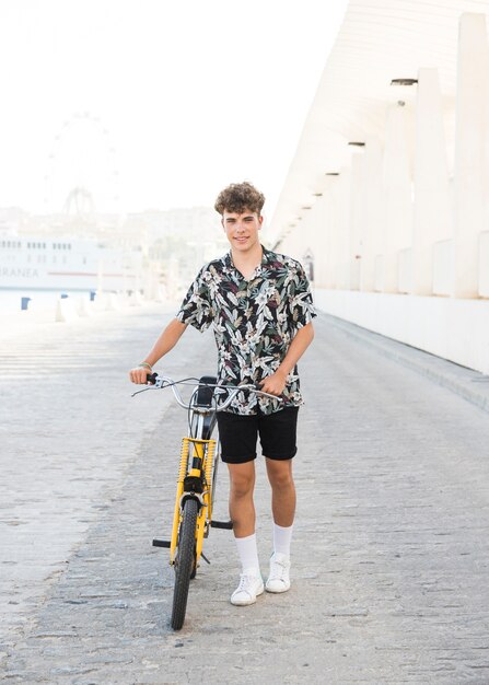 Portrait of a smiling young man with bicycle