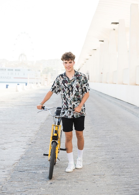 Портрет улыбающегося молодого человека с велосипедом
