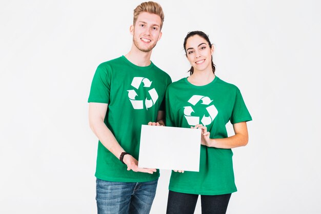 Portrait of smiling young man and woman holding blank white placard