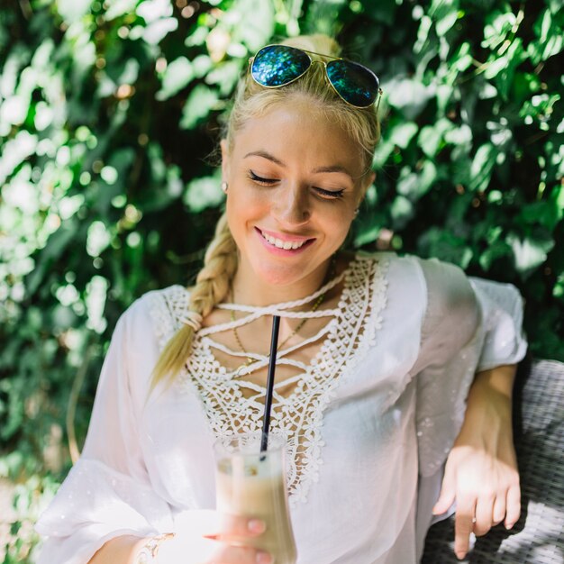 Portrait of a smiling young woman enjoying the drink