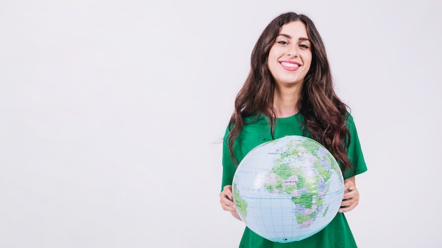 Portrait of a smiling young woman holding globe