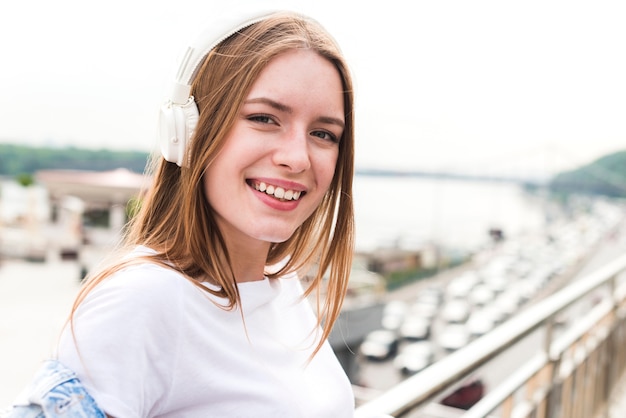 Портрет улыбающегося молодой женщины прослушивания музыки