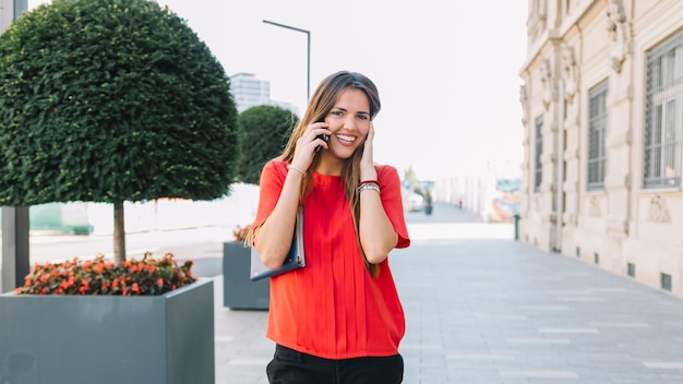 Portrait of a smiling young woman talking on cellphone