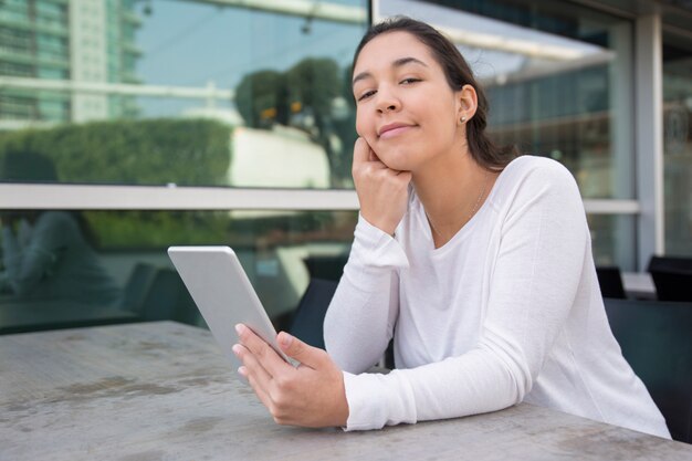 デジタルタブレットのカフェで笑顔の若い女性の肖像画