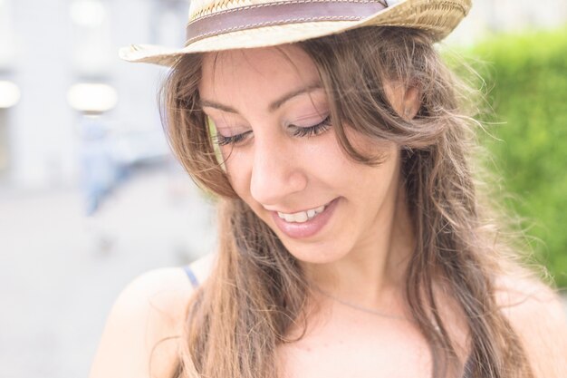 Портрет улыбающейся молодой женщины в шляпе